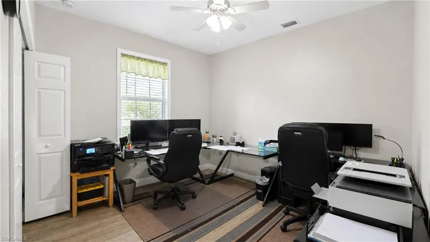 Bright room featuring wood-finish flooring and a ceiling fan