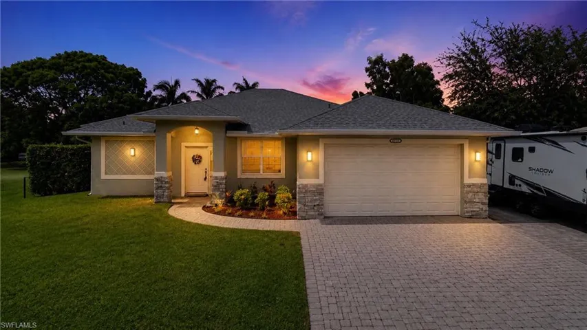 Single-story residence featuring a paver driveway, an attached two-car garage, and a covered entry
