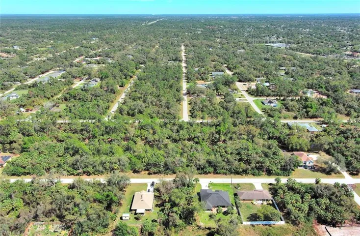 Aerial view of property and surrounding area with a heavily wooded area
