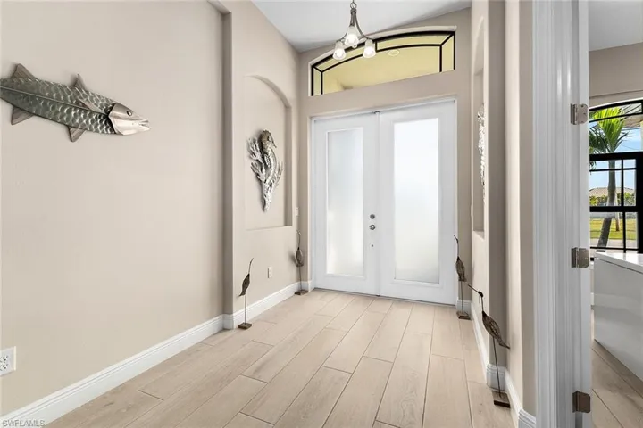 Foyer entrance featuring a chandelier and French doors