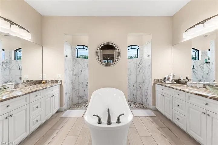 Bathroom with vanity, plenty of natural light, and separate shower and tub