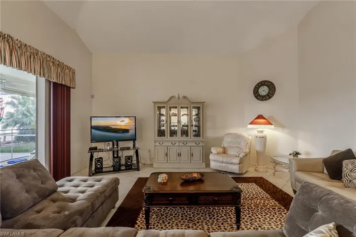 Kitchen with tasteful backsplash, light countertops, a kitchen breakfast bar, white cabinetry, and recessed lighting