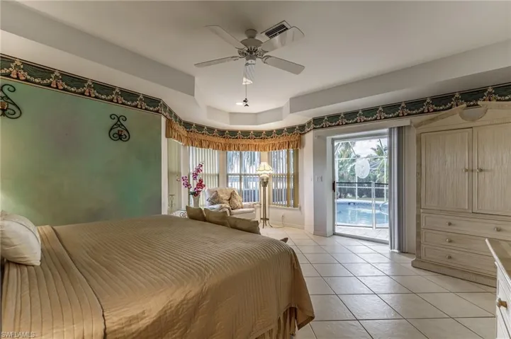 Bedroom featuring light tile patterned flooring, ceiling fan, and access to exterior