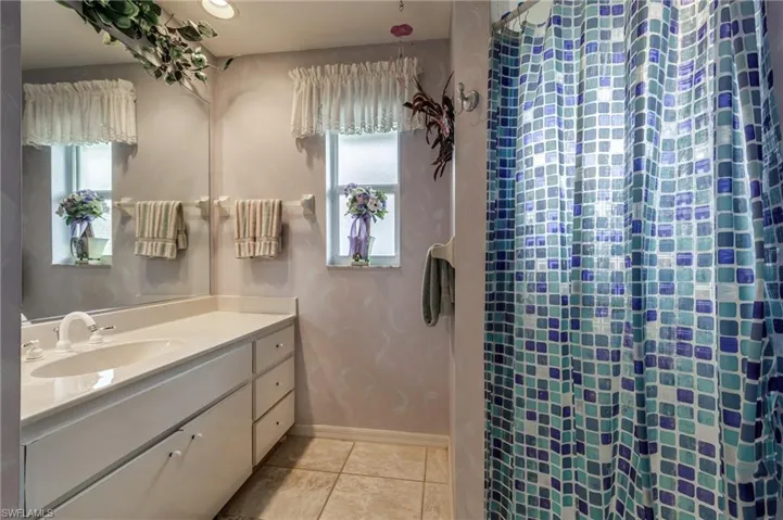 Full bathroom featuring vanity, light tile patterned floors, a stall shower, healthy amount of natural light, and recessed lighting