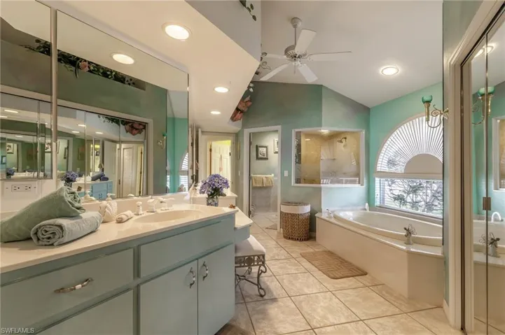 Full bathroom with a garden tub, vanity, light tile patterned flooring, a shower with shower door, and ceiling fan