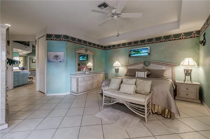 Bedroom with light tile patterned floors, ceiling fan, and a closet