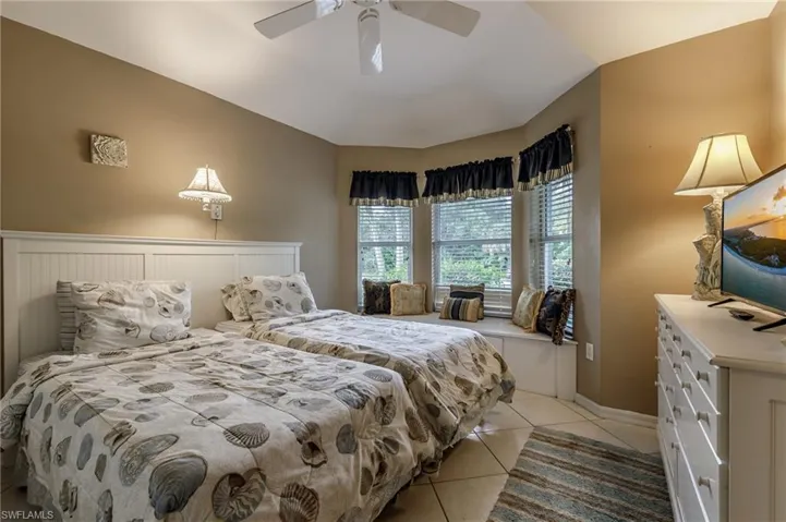 Bedroom with light tile patterned floors and a ceiling fan
