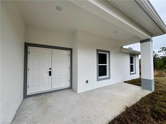 Entrance to property with a covered patio area