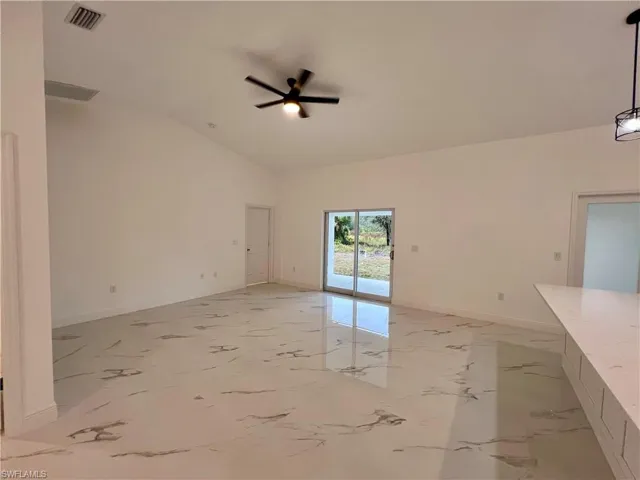 LIVING ROOM featuring ceiling fan and high volume ceilings.
