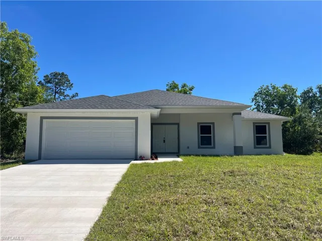 Ranch-style home with stucco siding, a covered front porch, a garage, and driveway with plenty of parking.