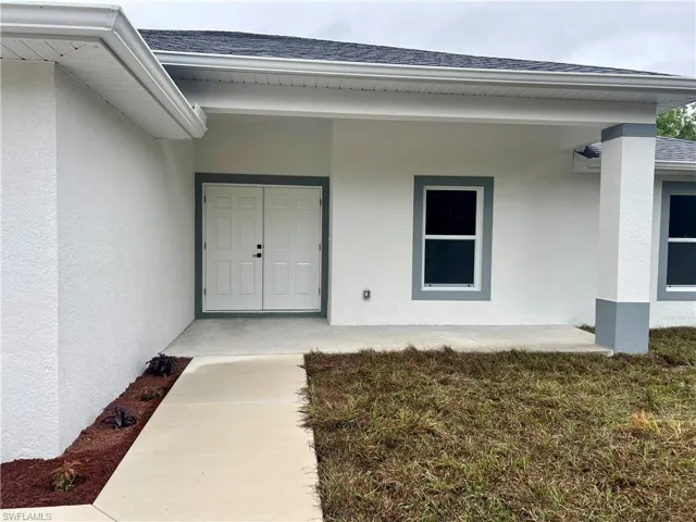 View of exterior entry with a covered front porch.