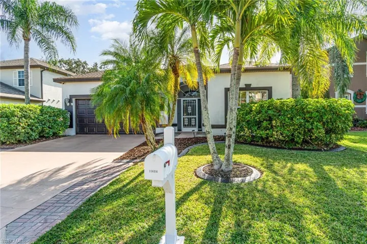 View of front of home featuring concrete driveway, stucco siding, an attached garage, and a front yard