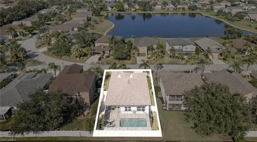 Aerial perspective of suburban area featuring a large body of water and property boundaries highlighted