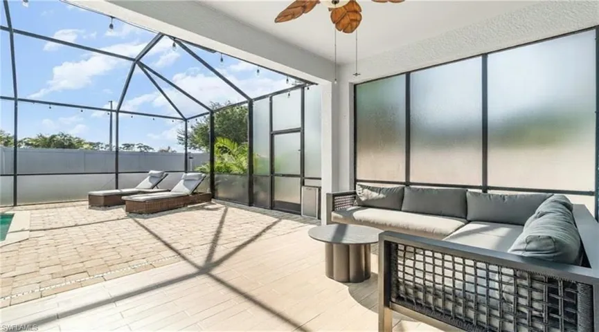 View of patio featuring an outdoor hangout area, a sunroom, glass enclosure, and a ceiling fan