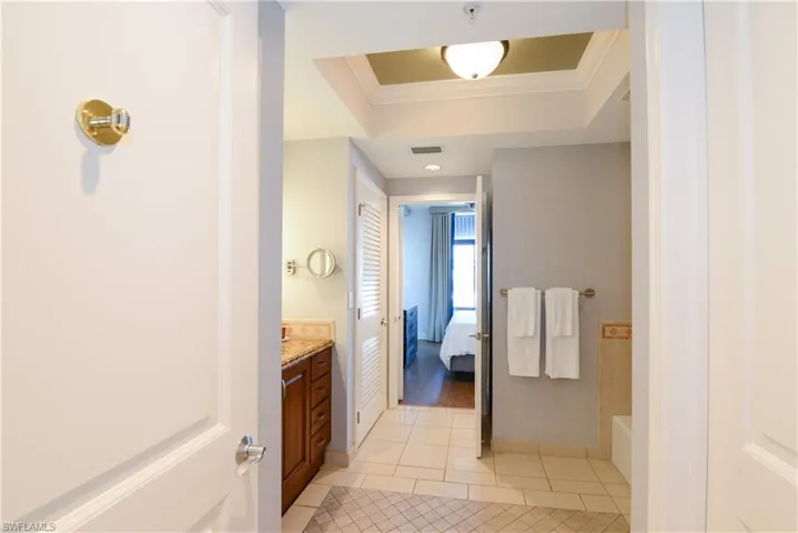 Bathroom with tile patterned flooring, crown molding, vanity, ensuite bathroom, and baseboards
