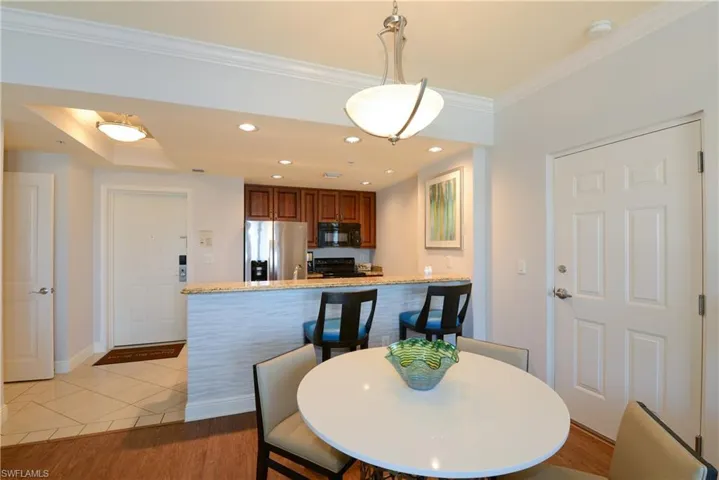 Dining space with crown molding, baseboards, and light tile patterned floors