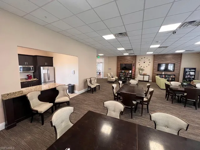 Dining room with a drop ceiling and dark colored carpet