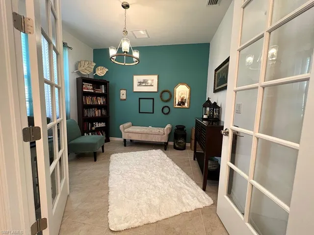 Home office featuring french doors, suspended lighting, and light tile patterned flooring