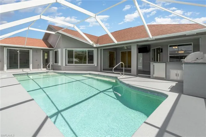 View of swimming pool featuring a patio, glass enclosure, and ceiling fan