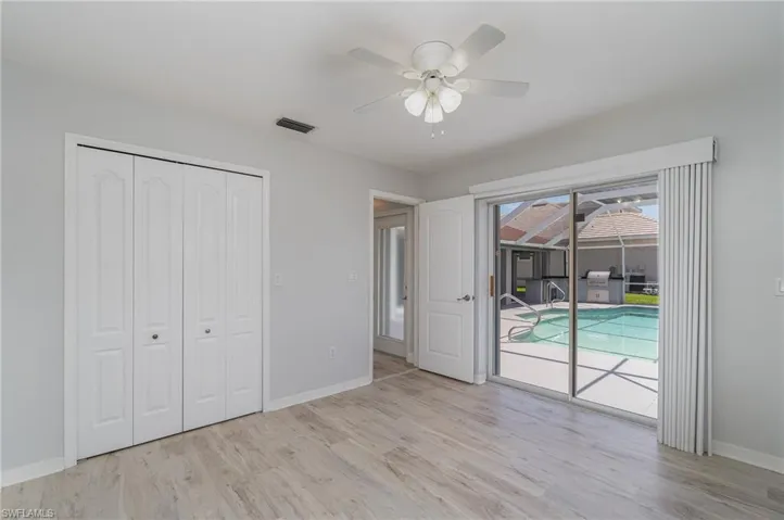 Unfurnished guest bedroom with access to outside, a closet, ceiling fan, and multiple windows