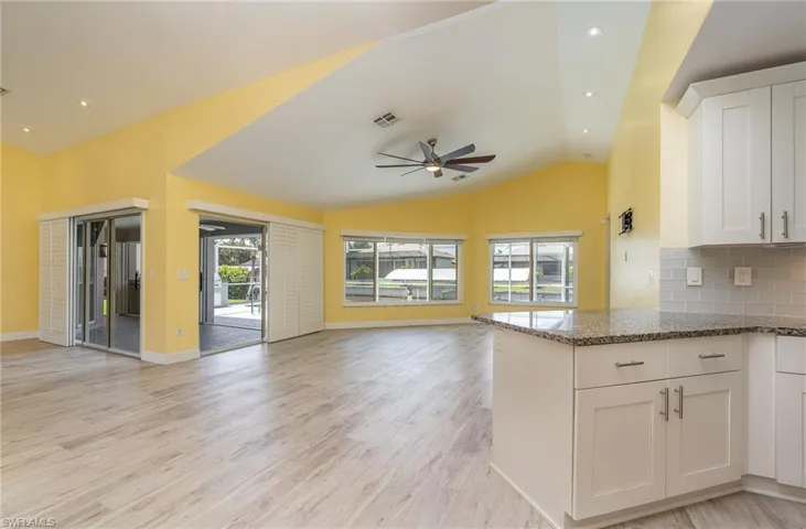 Kitchen featuring white cabinetry, tasteful backsplash, plenty of natural light, and light hardwood / wood-style flooring