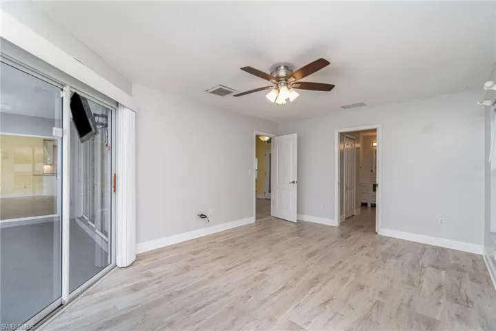 Primary bedroom with ceiling fan and light hardwood / wood-style flooring