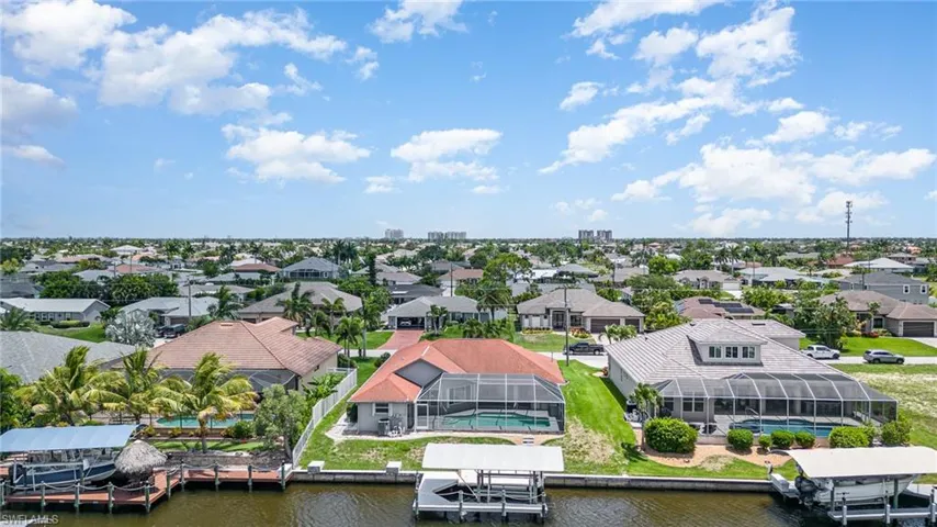 Aerial view of the back of home, dock and canal.