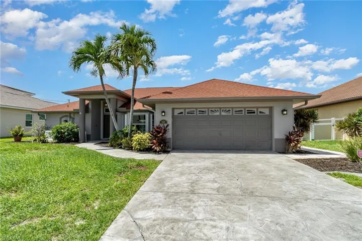 Ranch-style home featuring a garage and a front yard