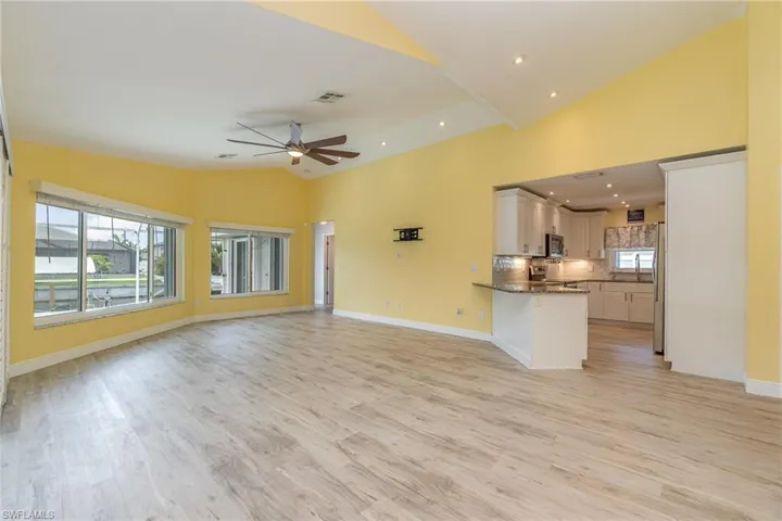 Unfurnished living room area featuring high vaulted ceiling, ceiling fan, and light hardwood / wood-style floors