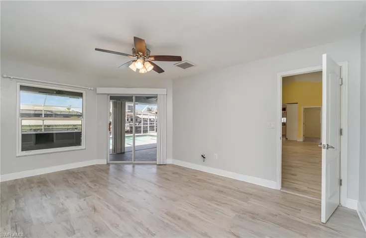 Primary bedroom with light wood-type flooring and ceiling fan