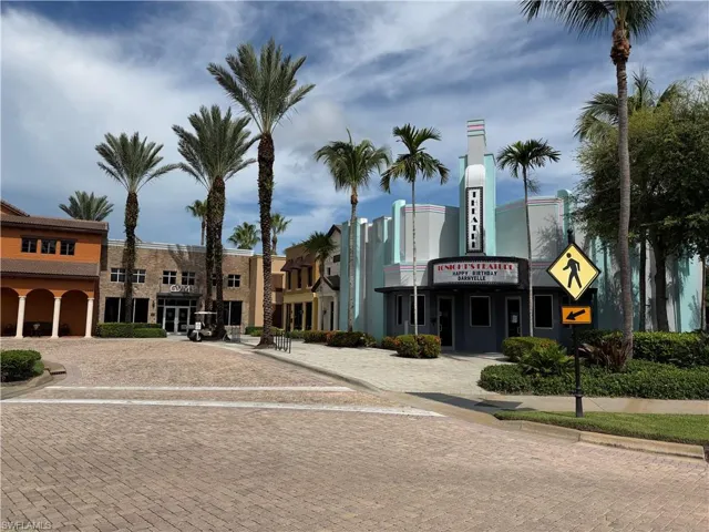 Commercial plaza featuring Art Deco architecture, paved brick thoroughfare, and mature palm landscaping
