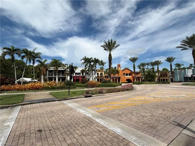Paver street featuring mature palm trees, manicured landscaping, and architectural buildings