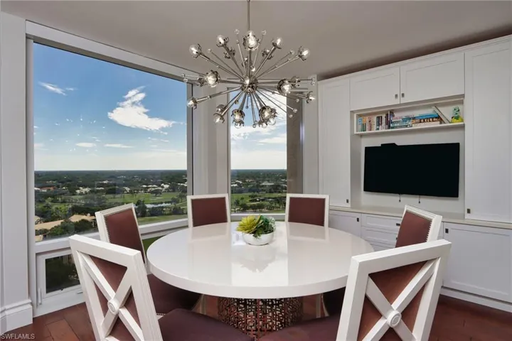 Dining area with an inviting chandelier and dark hardwood / wood-style floors