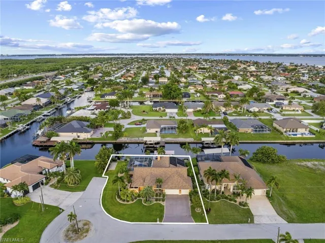 Aerial view of property and surrounding area with a large body of water and nearby suburban area