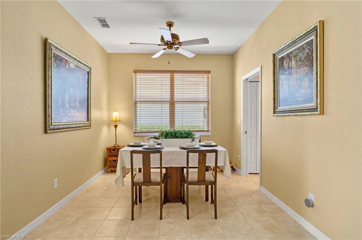 Dining space featuring light tile patterned floors, baseboards, a ceiling fan, and visible vents
