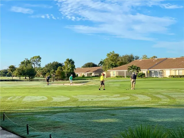 Surrounding community featuring view of golf course, a lawn, and a residential view