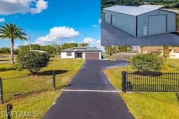 Ranch-style home featuring an outbuilding and driveway