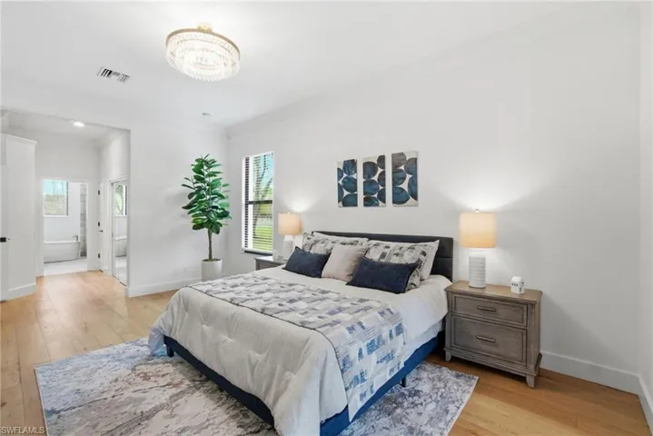 Bedroom featuring light wood floors and en-suite bathroom