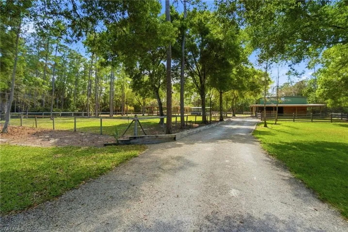 The gravel driveway connects the house to the stables/detached garage