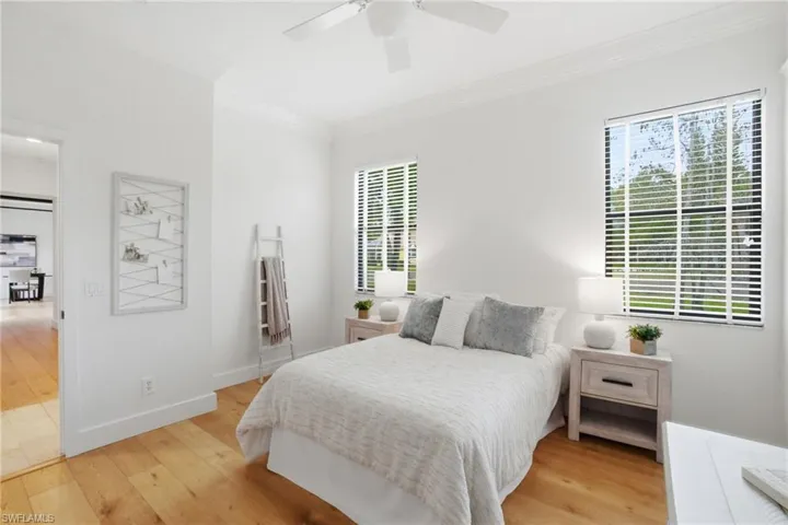 Bedroom featuring ornamental molding, light wood-type flooring, and ceiling fan