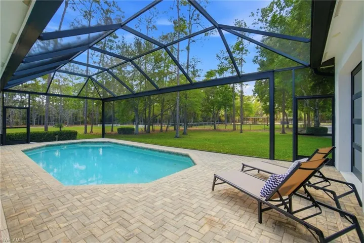 Heated swimming pool featuring a screened lanai,