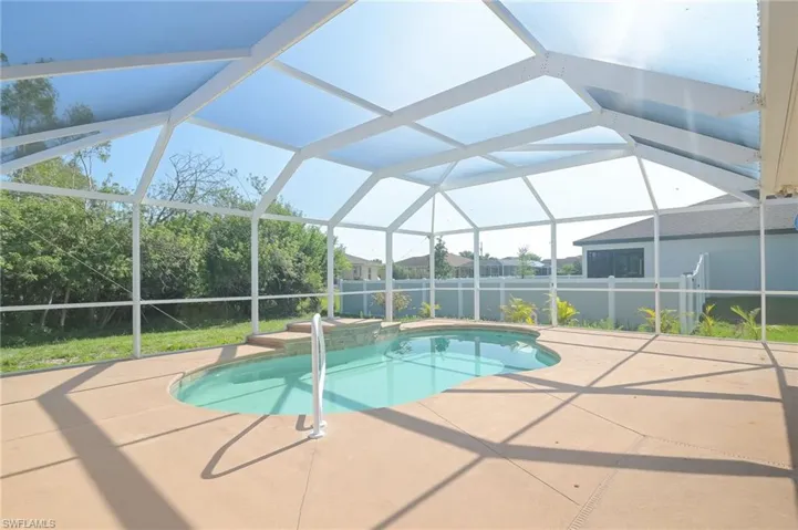 View of pool with a patio area and screen enclosure