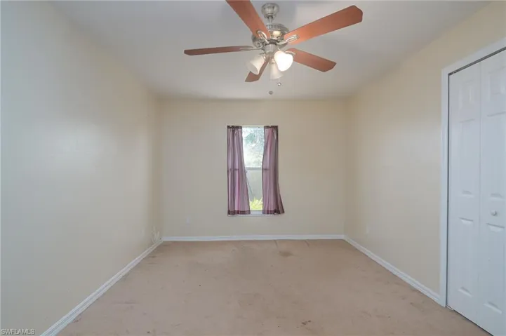 Unfurnished bedroom featuring ceiling fan and carpet floors