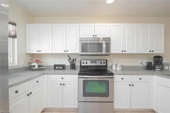 Kitchen featuring stainless steel appliances and white cabinetry