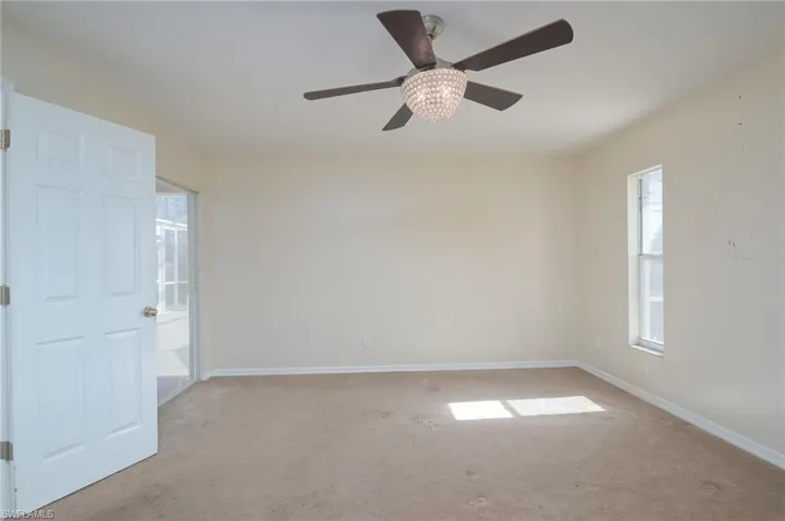 Carpeted empty room featuring ceiling fan