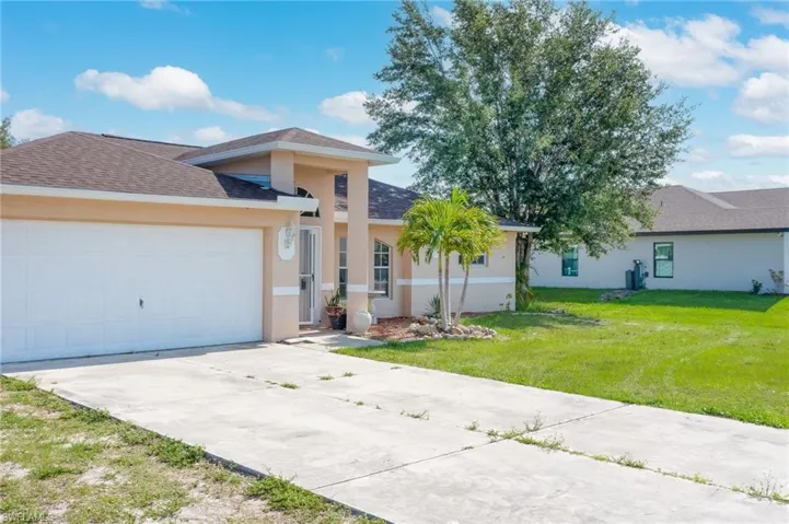 View of front of home featuring a front lawn and a garage