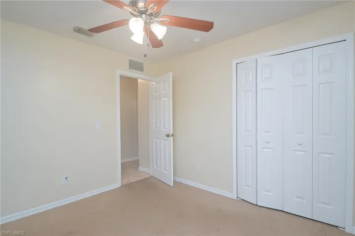 Unfurnished bedroom featuring a closet, ceiling fan, and carpet floors