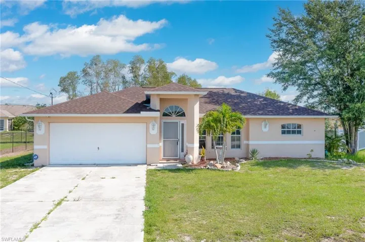 Single story home with a garage and a front yard