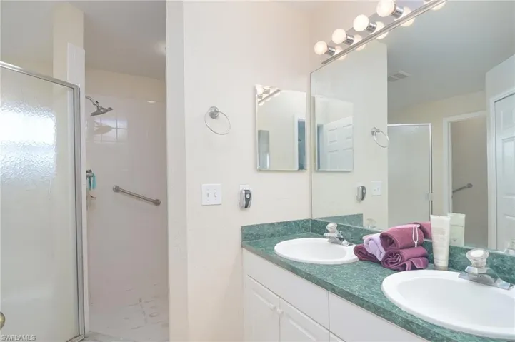 Bathroom with dual bowl vanity and an enclosed shower