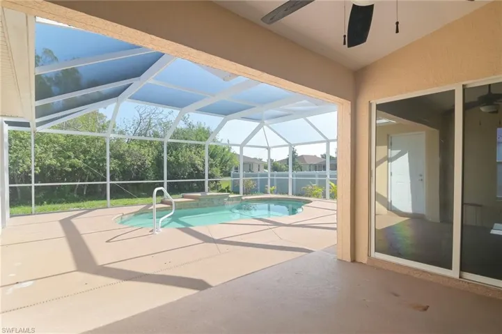View of swimming pool featuring a jacuzzi, a patio area, and ceiling fan